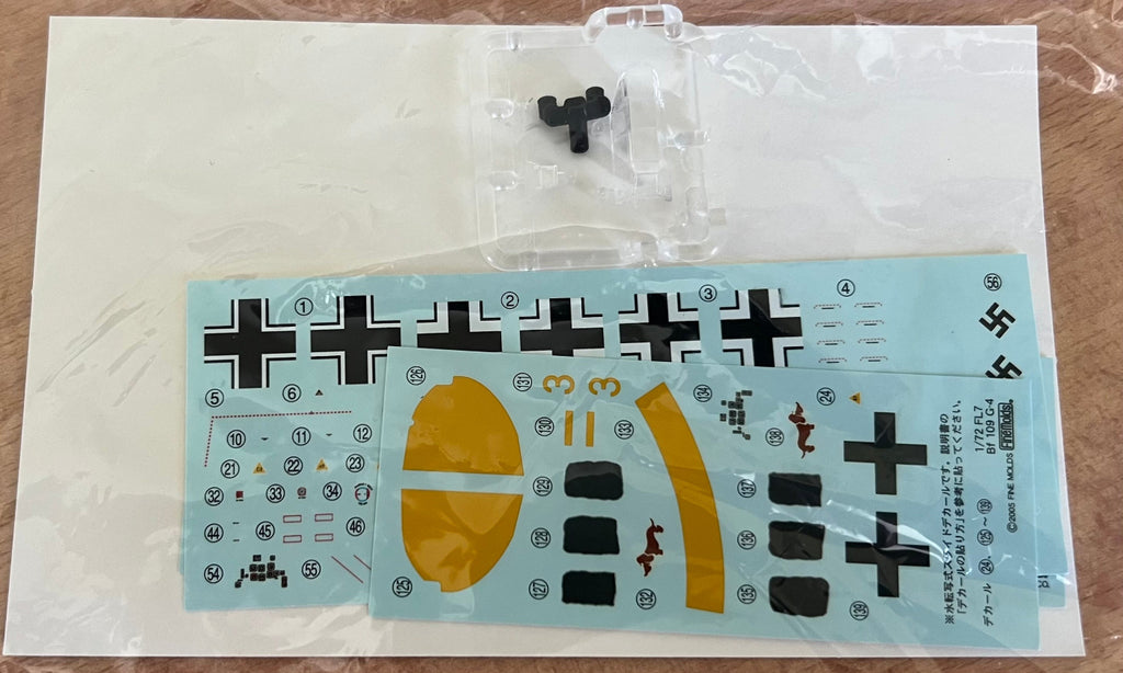 Model kit with decals and parts on a brown surface
