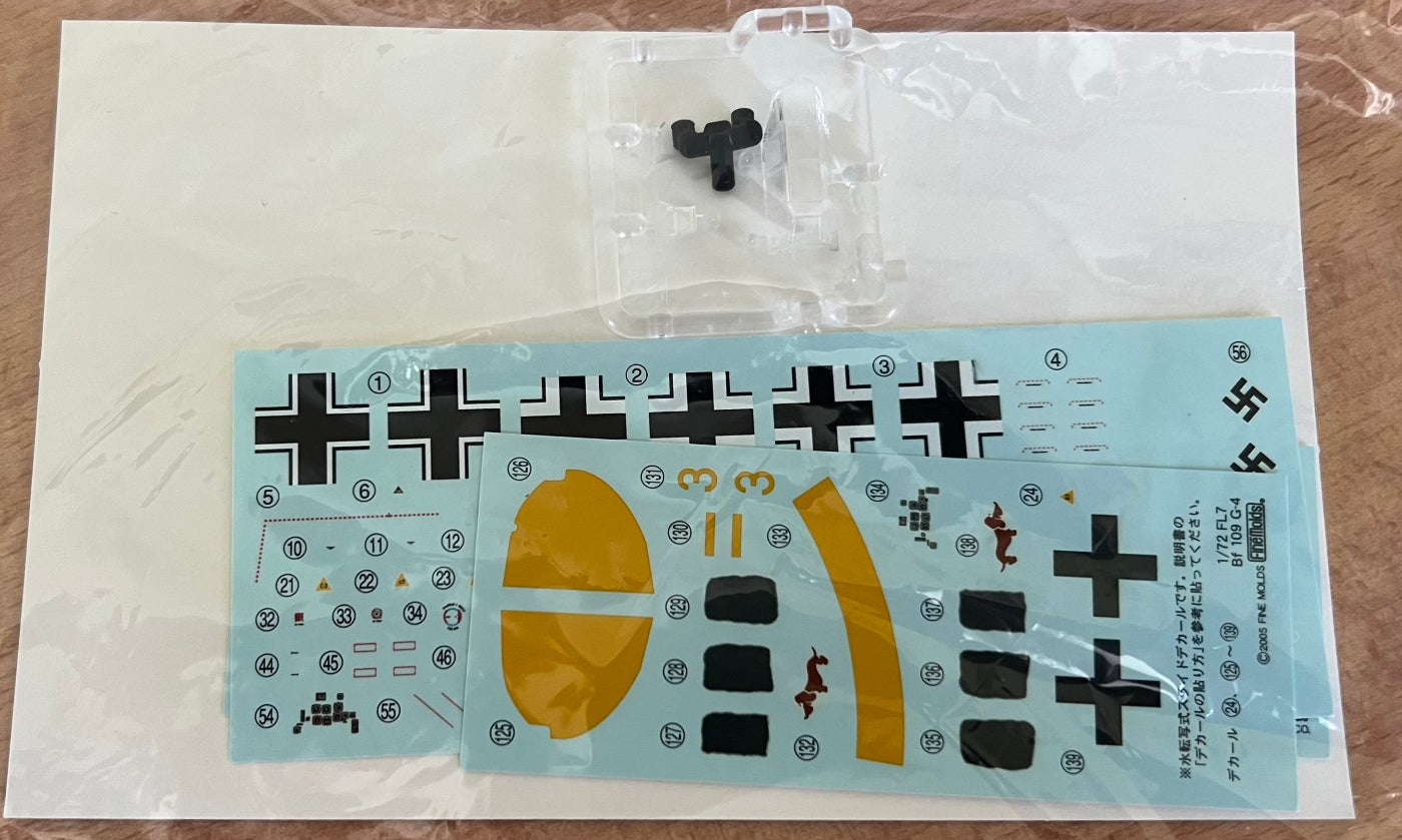 Model kit with decals and parts on a brown surface