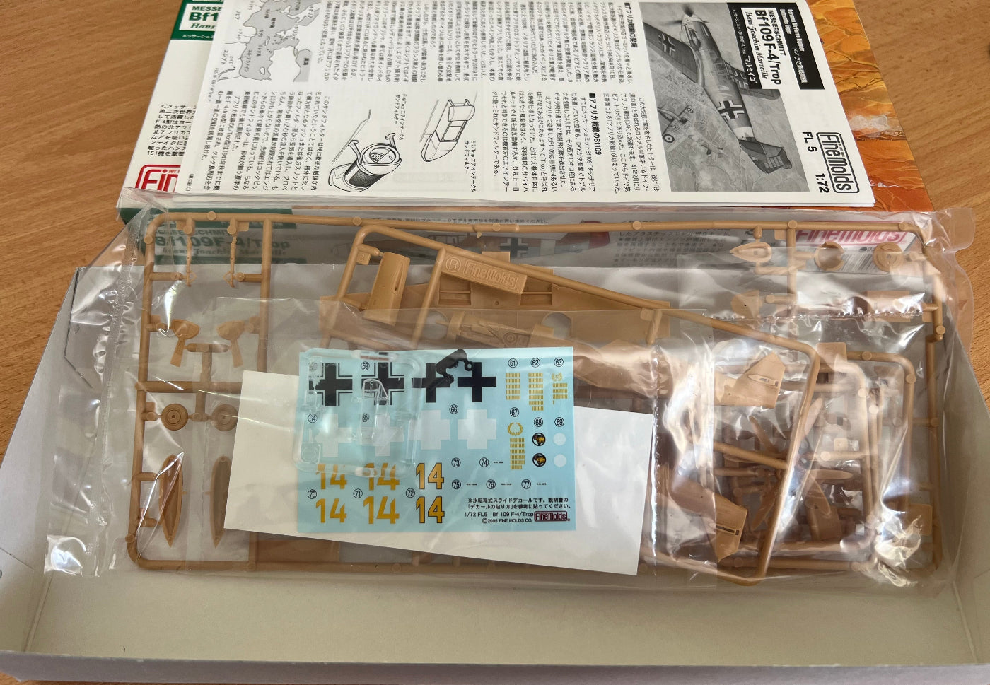 plastic model parts in a poly bag on a wooden background