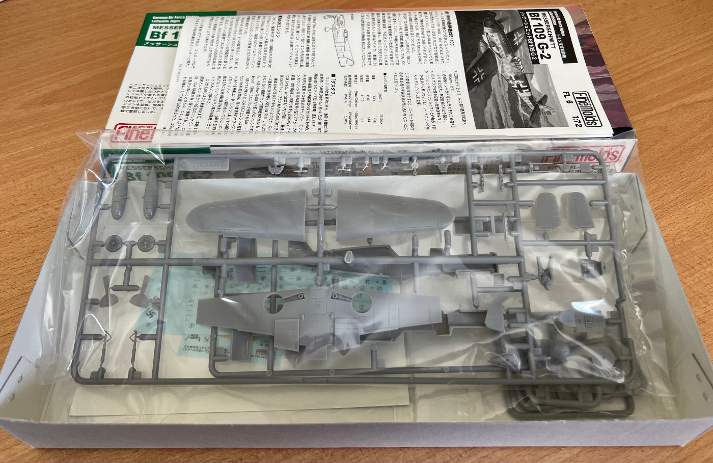 Model kit packaging with instructions on a wooden surface