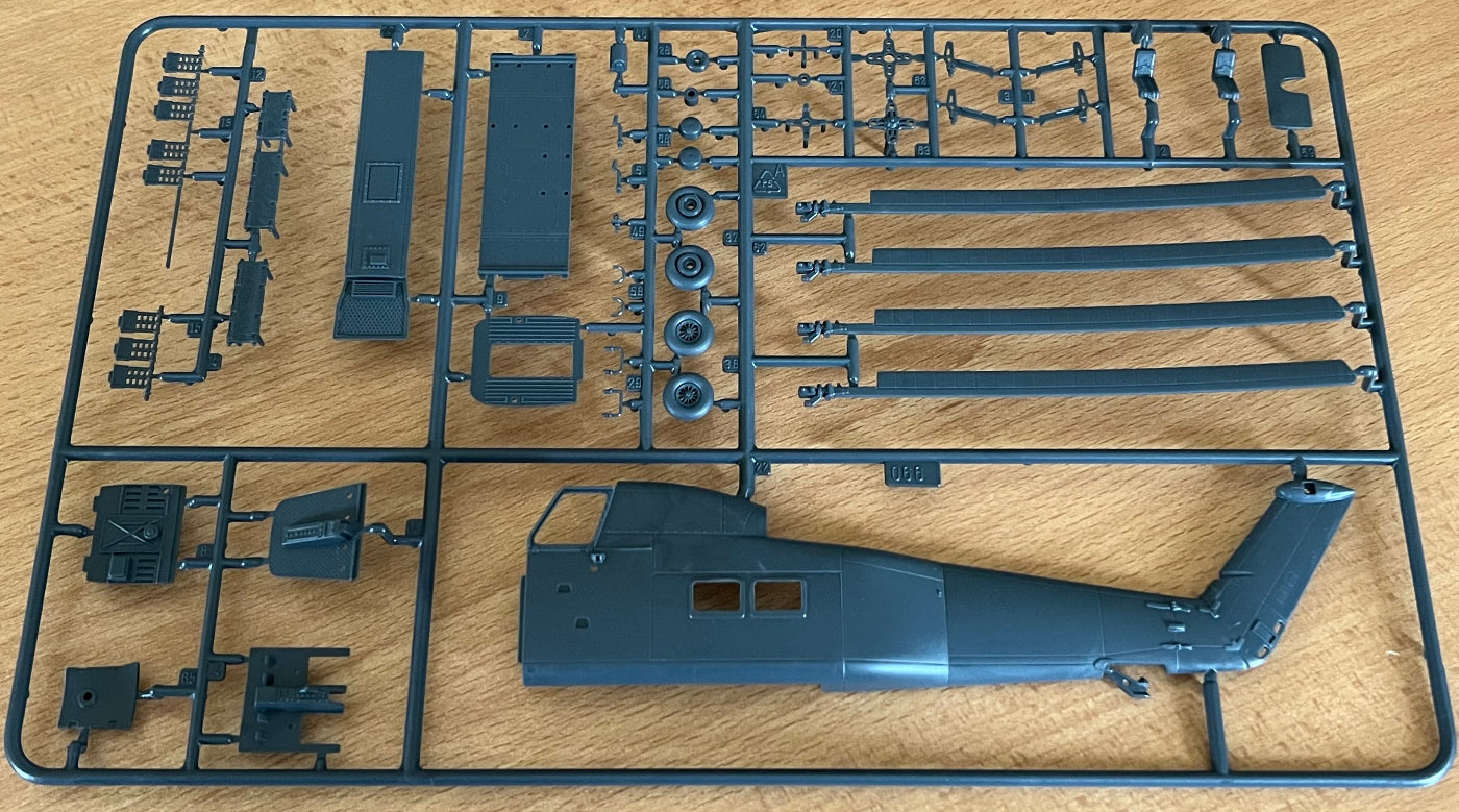 Model helicopter kit parts on a wooden surface
