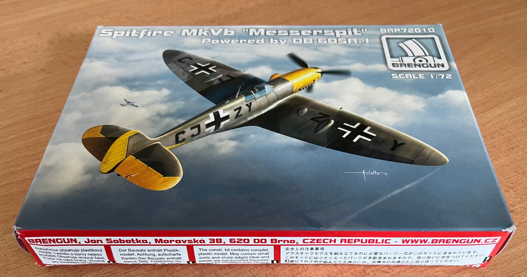 Model airplane kit box with Spitfire MkVb Messerschmitt design on a wooden surface