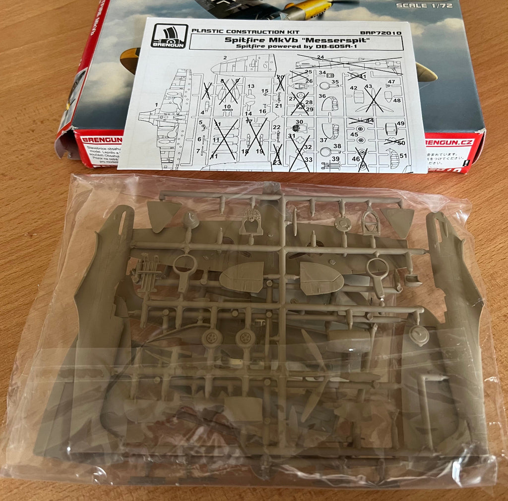 Model kit packaging with parts and instructions on a wooden surface