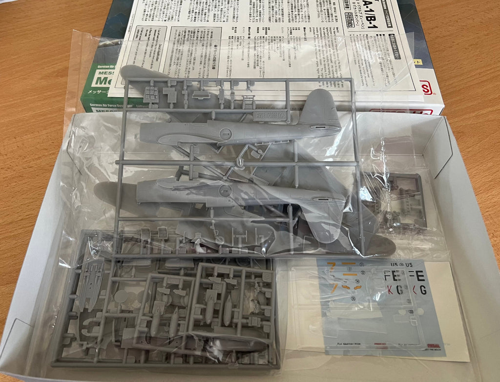 Model airplane kit with parts on a wooden surface