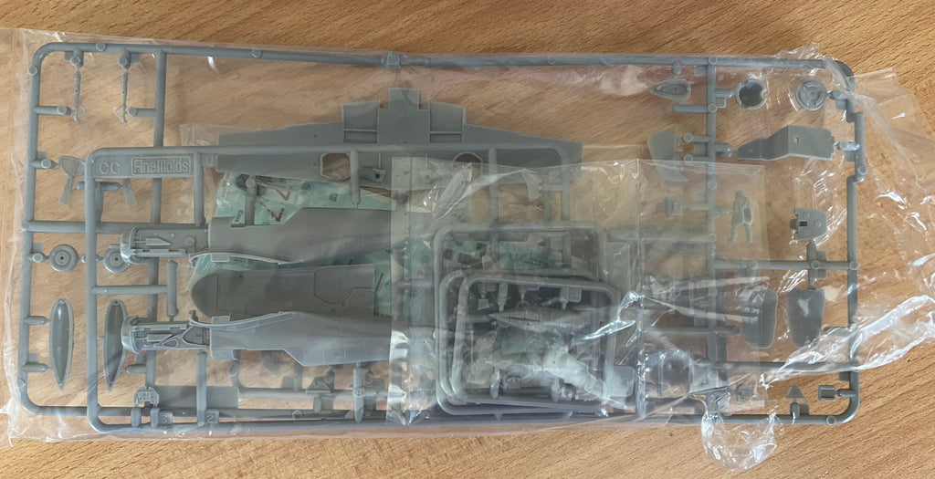 plastic model kit parts in cellophane bag on a wooden background