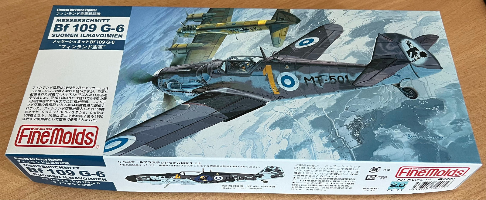 Model airplane kit box for Messerschmitt Bf 109 G-6 by FineMolds on a wooden surface.