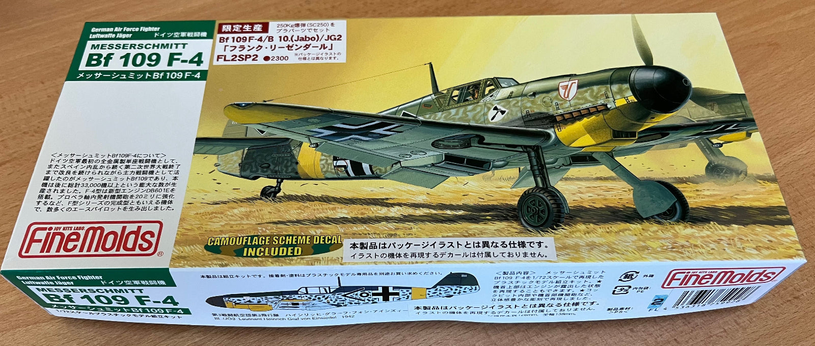 Model airplane kit box for Bf 109 F-4 by FineMolds on a wooden surface.