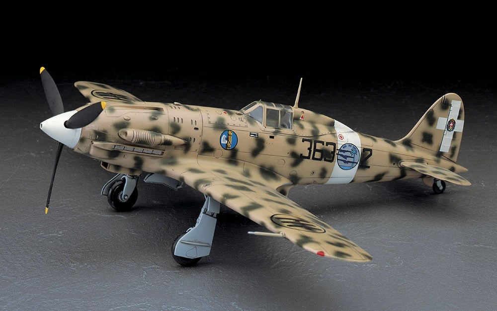 Model airplane with camouflage paint job on a dark background