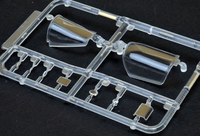 Clear plastic model kit component on a black background