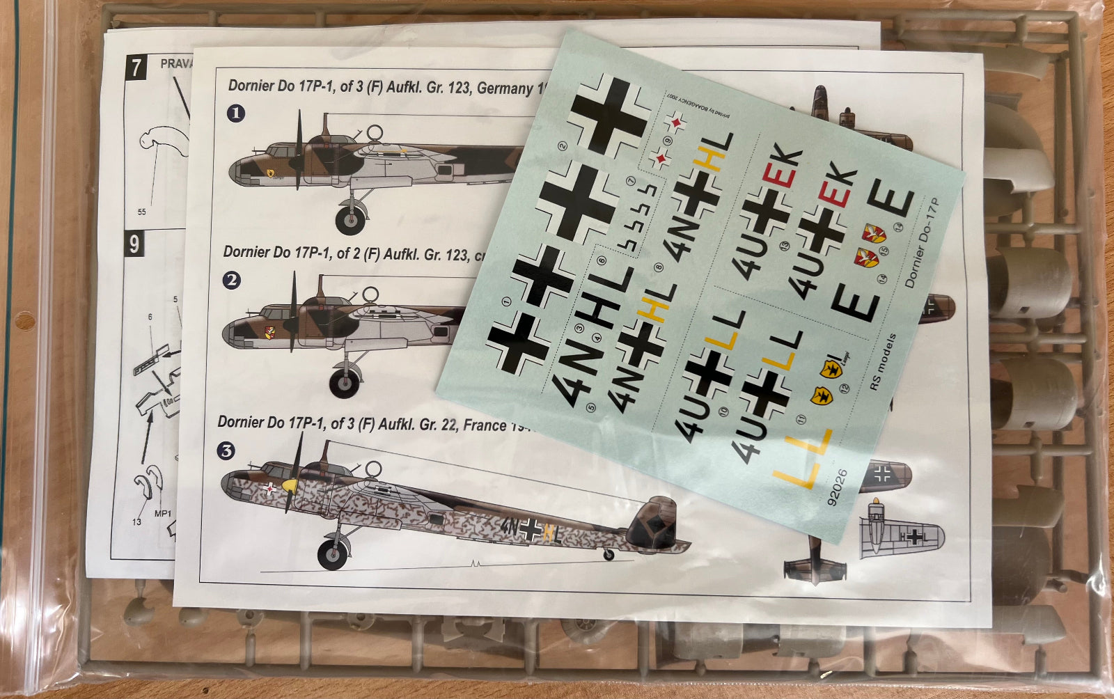 Model airplane decals with a sheet of cross-shaped markers on a plastic model kit background.